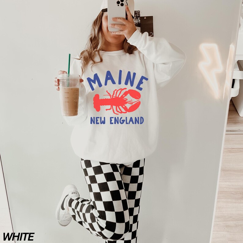 May include: White sweatshirt with a red lobster graphic and the text "Maine New England".