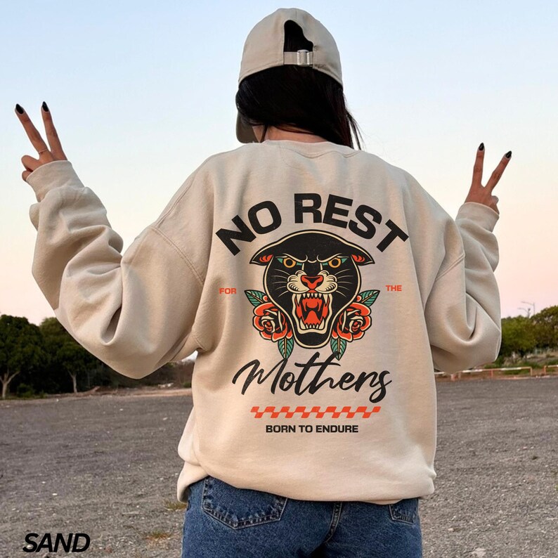 May include: A beige sweatshirt with a black panther graphic and the text "No Rest For The Mothers Born To Endure".