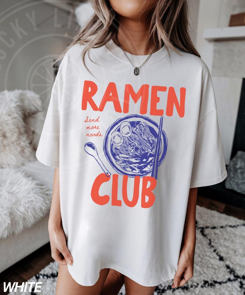 May include: White oversized t-shirt with a graphic of a bowl of ramen noodles and the text "Ramen Club" with the words "send more noodles" underneath.