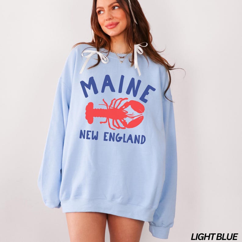 May include: Light blue sweatshirt with a graphic of a lobster and the text "Maine New England".