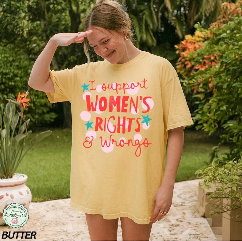 Peut inclure: T-shirt jaune avec l'inscription "I support WOMEN'S RIGHTS & Wrongs" en rouge et rose. Le design comprend des &eacute;toiles et des pois. Le t-shirt a une coupe ample et est fait d'une mati&egrave;re douce.