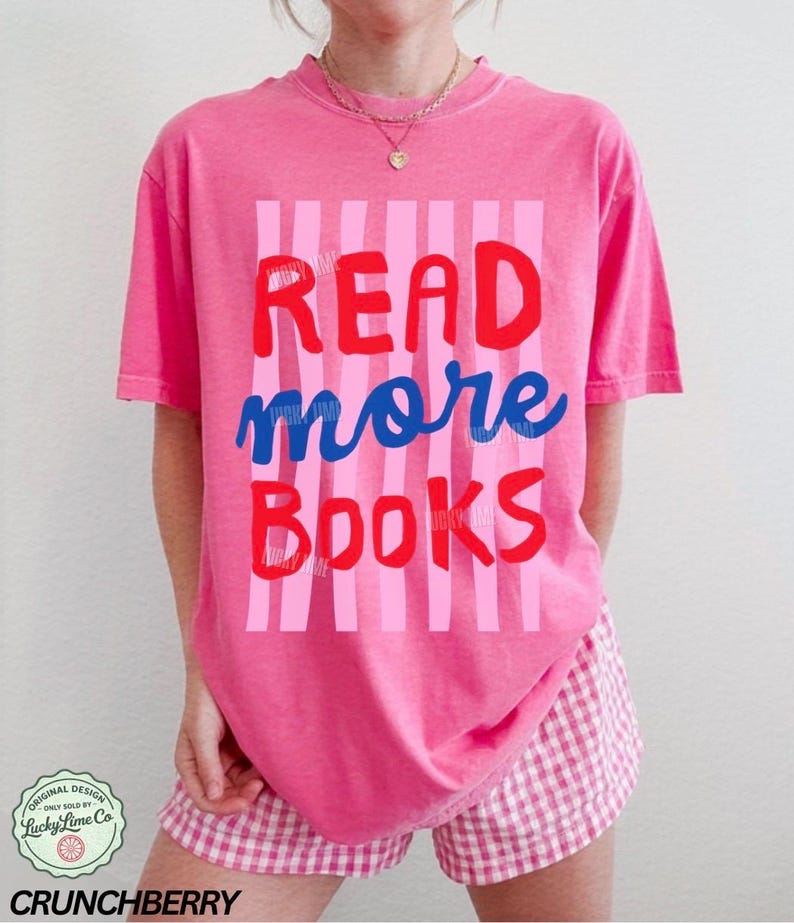 Puede incluir: Una camiseta rosa con las palabras "READ more BOOKS" en rojo y azul, sobre un fondo de rayas rosas. Se combina con pantalones cortos a cuadros rosas y blancos. El dise&ntilde;o incluye un logotipo que dice "Lucky Lime Co" y la palabra "CRUNCHBERRY".