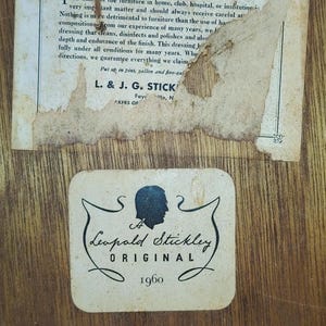 May include: A vintage label with the text "Important Instructions" and "L. & J. G. STICK" followed by a label with a silhouette of a person and the text "A Leopold Stickley ORIGINAL 1960" and a smaller label with the text "STICKLEY MANUFACTURERS SYRACUSE, NY".