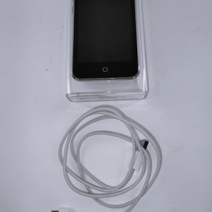 May include: A black iPod Nano in a clear plastic case with a white USB cable.