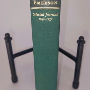 K&ouml;nnte beinhalten: Ein gr&uuml;nes Hardcover-Buch mit goldenen Lettern auf dem R&uuml;cken. Der Titel lautet "EMERSON Selected Journals 1841-1877".