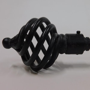 May include: Black metal cabinet knob with a decorative cage design. The knob has a rounded end and a cage-like structure with a square base. The hardware is designed for furniture and cabinets.