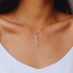 May include: A gold necklace with a graduation cap charm and the word "Sophia" written in cursive.