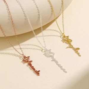 May include: Three gold necklaces with personalized name pendants. The necklaces are on a white background. The names on the pendants are "Amanda", "Olivia", and "Ashley".