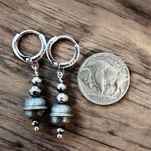 May include: Sterling silver hoop earrings with a silver and grey bead dangle. The dangle features three beads and a decorative silver charm. The earrings are shown next to a UK five pence coin for size reference.