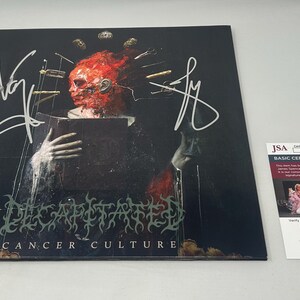 May include: A signed vinyl record album with a dark cover featuring a surreal, red-toned figure holding a book. The album title "Cancer Culture" is visible. A JSA authentication sticker is present.
