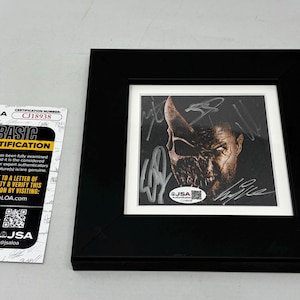 May include: Framed artwork featuring a detailed, signed image of a character with a mask. The black frame surrounds the image, which is set against a white mat. A JSA Basic Certification card is on the left.