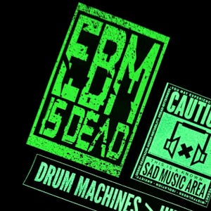 May include: A green and black sticker with the text "EBM is DEAD" and "DRUM MACHINES".  A second sticker with the text "CAUTION" and "THIS IS A KNOWN SAD MUSIC AREA" is visible in the background.