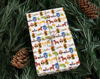 May include: A wrapped gift with a festive Mexican-themed pattern. The white wrapping paper features colorful illustrations of luchador masks, maracas, sombreros, and other cultural icons. The gift is tied with twine and set against a backdrop of pine needles and pine cones.