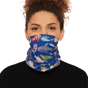 May include: A blue face mask with a colorful pattern of sea creatures, including fish, a turtle, a shark, and an octopus.
