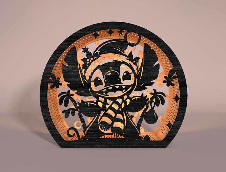 May include: A black and orange wooden laser-cut decoration featuring a cartoon character wearing a Santa hat and scarf. The design includes palm trees and ornaments, set within a circular frame. The character is smiling.