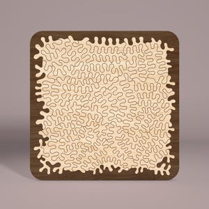 May include: A wooden jigsaw puzzle with a brown frame and a light wood interior. The puzzle features a complex, intricate design of swirling, organic shapes.