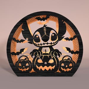 May include: A black and orange Halloween decoration featuring a cartoon character and pumpkins. The design is laser-cut from wood, with bats and a circular frame. The character is in the center, with jack-o'-lanterns below.