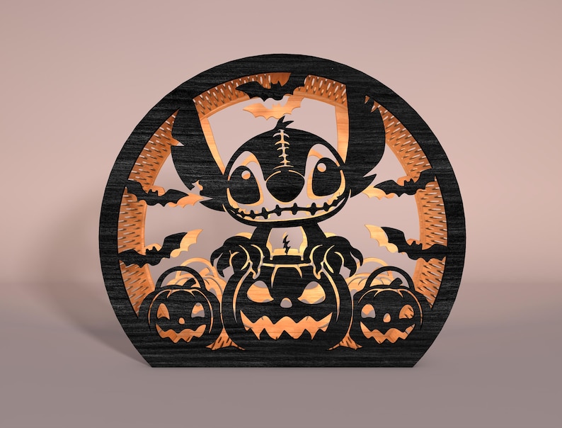 May include: A black and orange Halloween decoration featuring a cartoon character and pumpkins. The design is laser-cut from wood, with bats and a circular frame. The character is in the center, with jack-o'-lanterns below.