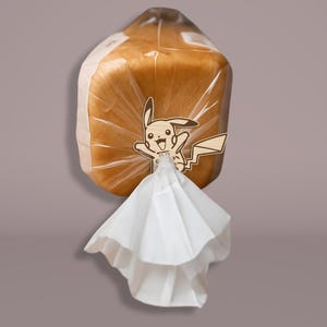 May include: A loaf of bread in a clear plastic bag, with a wooden Pikachu character attached. The bread is light brown, and the bag is sealed with a white paper element.