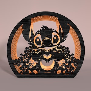 May include: A wooden, laser-cut decorative piece featuring a cartoon character. The design showcases a black silhouette of the character surrounded by a light-colored frame and floral accents. The character is holding a heart shape with its hands.