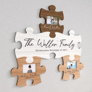 K&ouml;nnte beinhalten: Ein wei&szlig;er und brauner Holzpuzzle-Rahmen mit dem Text "The Waller Family Established November 27, 2017". Der Rahmen hat drei Fotoschlitze mit Bildern von Kindern.