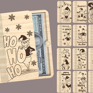Puede incluir: Una caja de regalo de madera con un diseño del Grinch y las palabras "HO HO HO" grabadas en la parte delantera. La caja está abierta, revelando un fajo de billetes de dólar estadounidenses. También se ven etiquetas de regalo adicionales con diseños temáticos del Grinch.