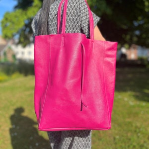 Handtasche bzw. Shopper in knalligem lila die Tasche ist cirka eine unterarm Länge hoch und breit. Die Tasche hat extrem viel Stauraum und kann mit einer Lederschnur zugeschnürt werden.