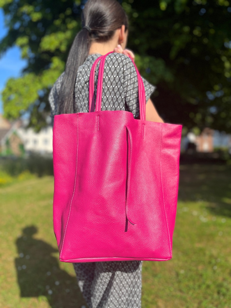 Handtasche bzw. Shopper in knalligem lila die Tasche ist cirka eine unterarm Länge hoch und breit. Die Tasche hat extrem viel Stauraum und kann mit einer Lederschnur zugeschnürt werden.