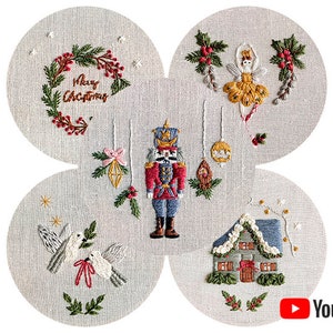 Puede incluir: Una tela blanca con cuatro secciones circulares, cada una con un diseño de bordado diferente con temática navideña. Los diseños incluyen un cascanueces, una bailarina, una corona con el texto "Feliz Navidad", una casa y dos palomas.