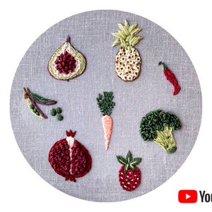 Peut inclure: Broderie de fruits et légumes sur un fond de tissu gris. Les motifs comprennent un ananas, une figue, un piment, une carotte, un brocoli, une grenade et une fraise.