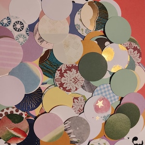 May include: A collection of various sized paper circles in a variety of colors and patterns. Some circles are solid colors, while others feature floral, geometric, and abstract designs. The color palette includes white, pink, green, gold, and blue.