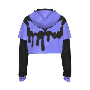 May include: A cropped hoodie with a black and periwinkle color scheme. The periwinkle hood and back panel feature a black bat wing design with dripping accents. The long sleeves are black, and the cuffs have a small bat wing design. The text "IMGirl Designs" is visible.
