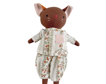 Puede incluir: Una muñeca de peluche hecha a mano con forma de ratón, vestida con un pijama con estampado floral. El ratón tiene la cabeza marrón, orejas rosas y una nariz rosa. El pijama es blanco con un estampado de hojas verdes y flores naranjas.