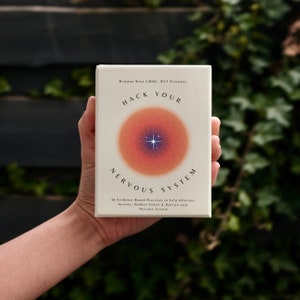 Könnte beinhalten: Eine weiße Karte mit einem roten und orangenen Kreis mit einem Stern in der Mitte. Der Text auf der Karte lautet "Hack Your Nervous System" und "60 Evidence-Based Practices to help Alleviate Anxiety, Reduce Stress & Retrain your Nervous System."