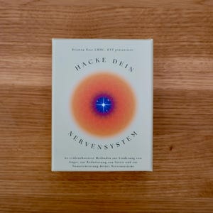 Könnte beinhalten: Buchcover mit hellblauem Hintergrund und einem großen orangen Kreis mit einem blauen Stern in der Mitte. Der Titel des Buches lautet "Hacke Dein Nervensystem" und der Untertitel lautet "60 evidenzbasierte Methoden zur Linderung von Angst, zur Reduzierung von Stress und zur Neuorientierung deines Nervensystems".