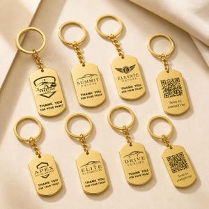 May include: Gold-colored metal keychains with various company logos and the text "THANK YOU FOR YOUR TRUST." Some keychains feature a QR code with the text "Scan to contact me."