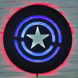 May include: A black circular wall decor with a white star in the center and blue and red LED lights around the edges.