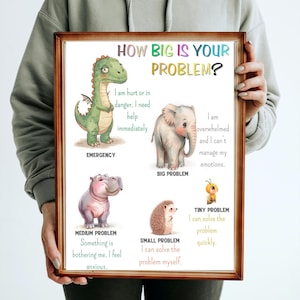 Pode incluir: Uma impressão emoldurada com o texto "HOW BIG IS YOUR PROBLEM?" e ilustrações de um dinossauro, elefante, hipopótamo, ouriço e abelha, cada um representando um tamanho de problema diferente. A impressão é segurada por uma pessoa.