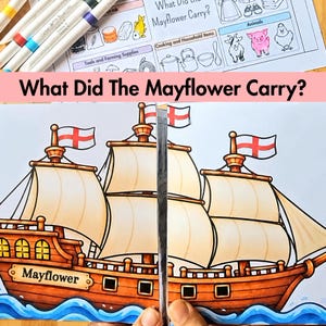 May include: A printed educational worksheet titled What Did The Mayflower Carry? featuring a large illustration of a brown wooden ship with white sails and red cross flags, alongside a chart of various items and animals.