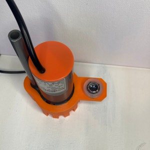 May include: An orange submersible pump with a black cord and a clear plastic cap. The pump has a label that reads "Neptune Systems DC12V 19W 2400 GPH Max Head 1.5m".