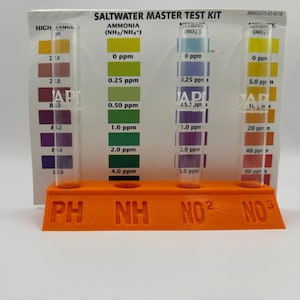 Può includere: Un kit di test master per acqua salata con quattro provette trasparenti in un supporto arancione brillante. Le provette sono etichettate con i seguenti parametri: pH, NH, NO2 e NO3. Le provette sono riempite con liquidi colorati che indicano i livelli di ammoniaca, nitrito e nitrato nell'acqua.