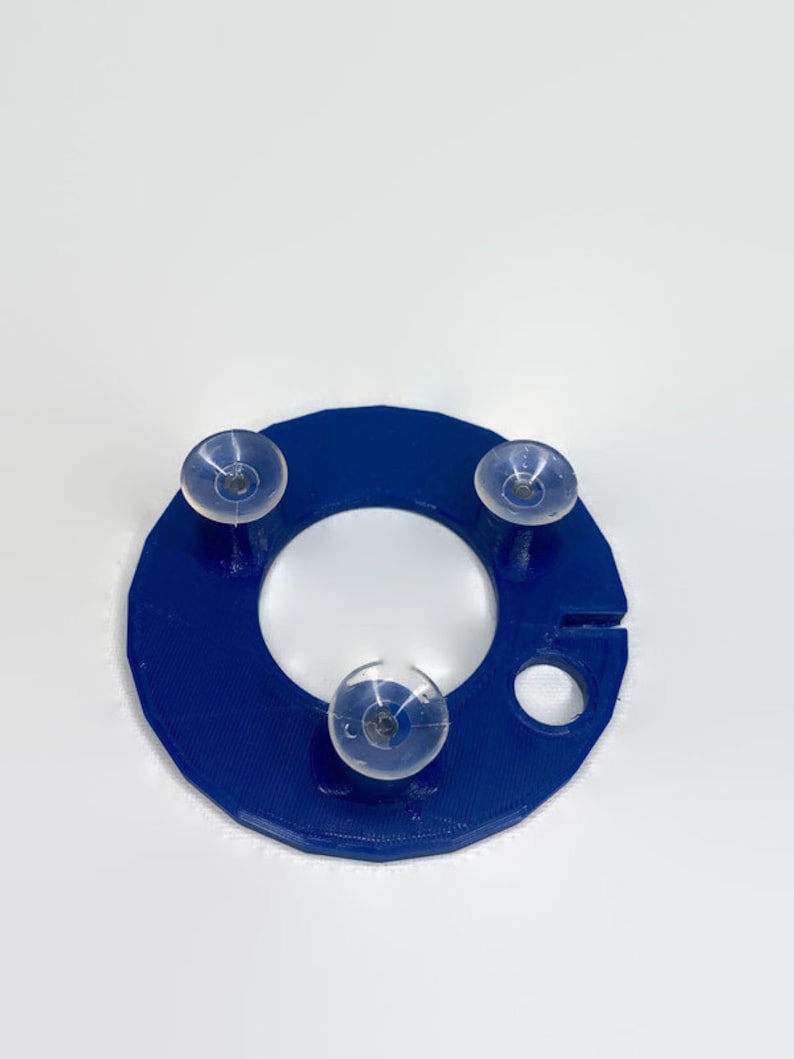 May include: A blue plastic ring with three suction cups attached. The ring has a small hole on the side.