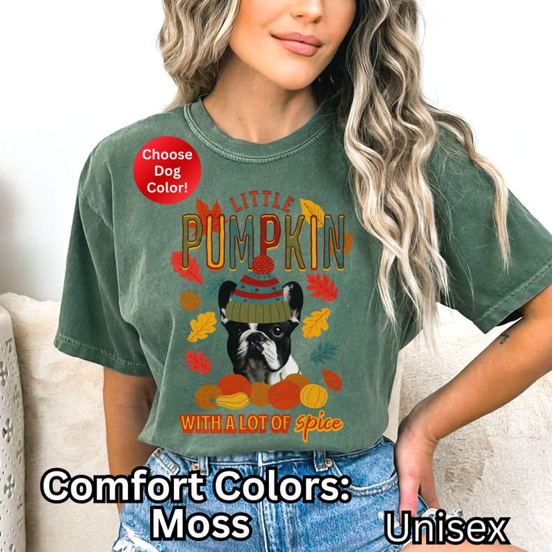 May include: A green t-shirt with a graphic of a dog wearing a hat and the text "Little Pumpkin with a lot of spice". The shirt is a unisex comfort color in moss.