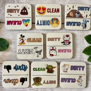 May include: Set of 8 white square ceramic coasters with black and colorful graphics. Each coaster has a "clean" and "dirty" side with different images. The images include a poop emoji, a heart-eyed smiley face, a crying smiley face, a cartoon dog, a cartoon cat, Mickey Mouse, a UFO, Hello Kitty, Baby Yoda, and a teacup.