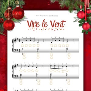 May include: Sheet music for "Vive le Vent" with musical notes and star decorations. The title is in a decorative font, with the composer's name and arranger's name above the title. Red Christmas ornaments and greenery frame the top and sides.