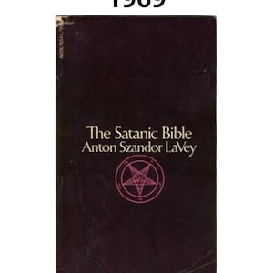 K&ouml;nnte beinhalten: Ein Vintage-Exemplar von "The Satanic Bible" von Anton Szandor LaVey. Das Buch hat einen dunkelburgunderfarbenen Einband mit dem Titel und dem Namen des Autors in Wei&szlig;. Ein rosa Pentagramm-Symbol ist mittig auf dem Einband platziert. Das Jahr "1969" ist oben aufgedruckt.