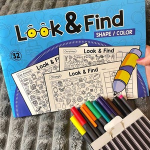 May include: A blue "Look & Find" activity book with 32 pages, featuring shape and colour themes. Includes a set of colourful markers in a striped box. The book has illustrations for colouring and finding activities.