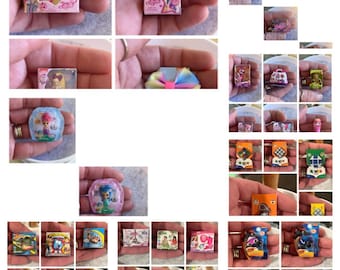 Może przedstawiać: Kolekcja miniaturowych zabawek i gier w różnych kolorach i wzorach, w tym różowa i fioletowa lalka, niebieska i zielona syrena, różowa i biała kokardka oraz różne gry planszowe.