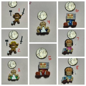May include: Set of eight Cabbage Patch Kids mini figures. The figures are in various poses and outfits, including a warrior, a baby, a TV head, and a brain-headed figure. Each figure is approximately 2.5 cm tall.