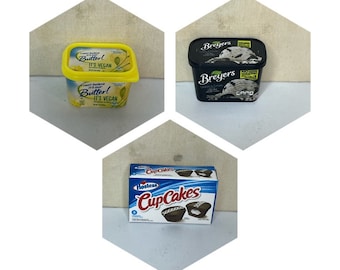 May include: Three miniature food items: a yellow tub of vegan butter labeled "Can't Believe It's Not Butter! It's Vegan", a black tub of Breyers ice cream, and a blue box of Hostess Cup Cakes.